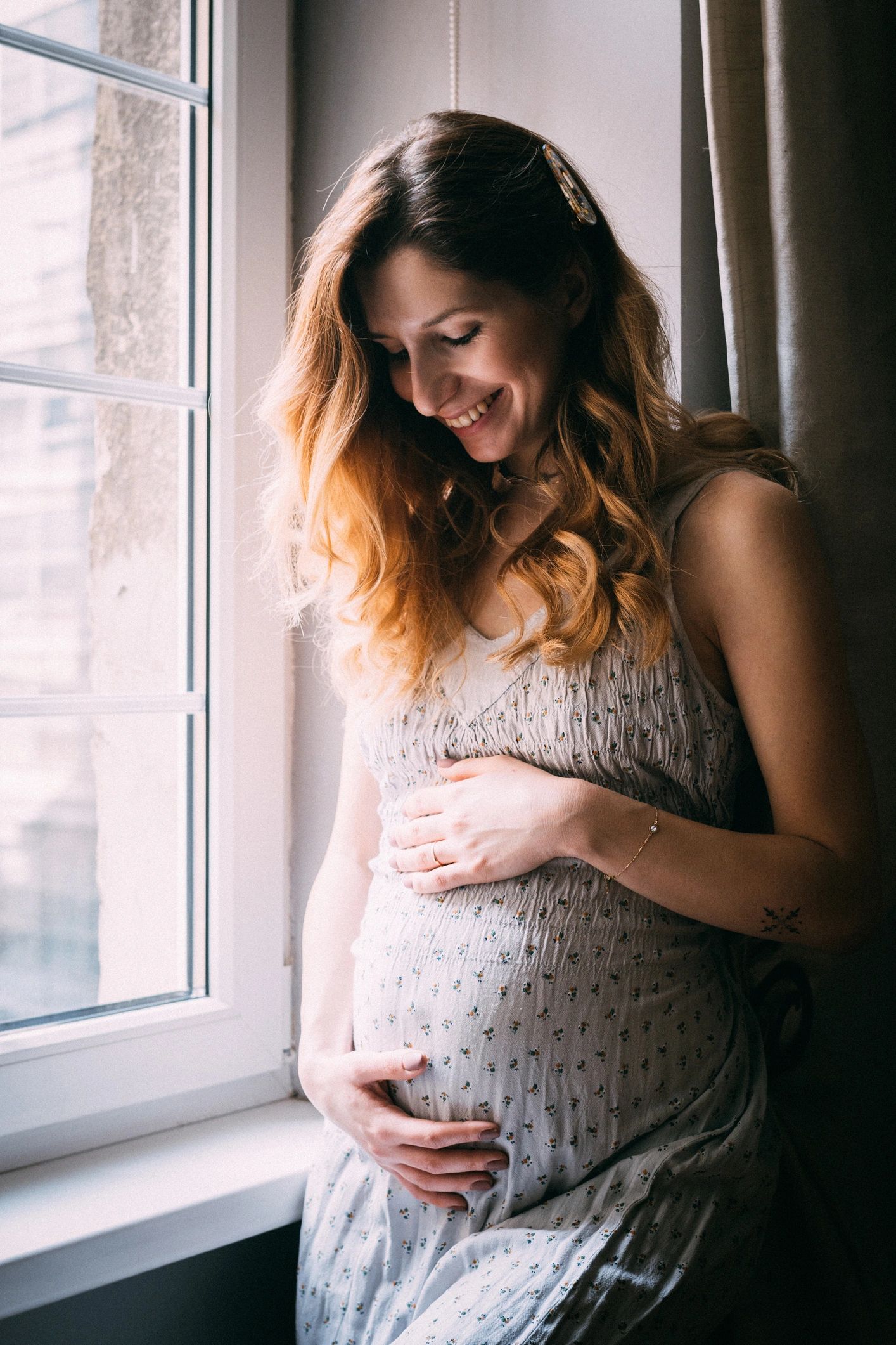 Pregnant woman smiling by window