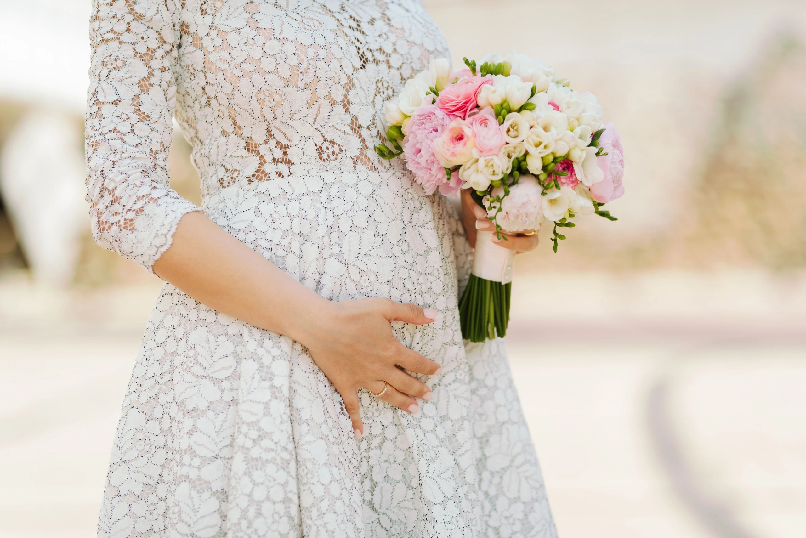 Close-up maternity portrait with hands on baby bump