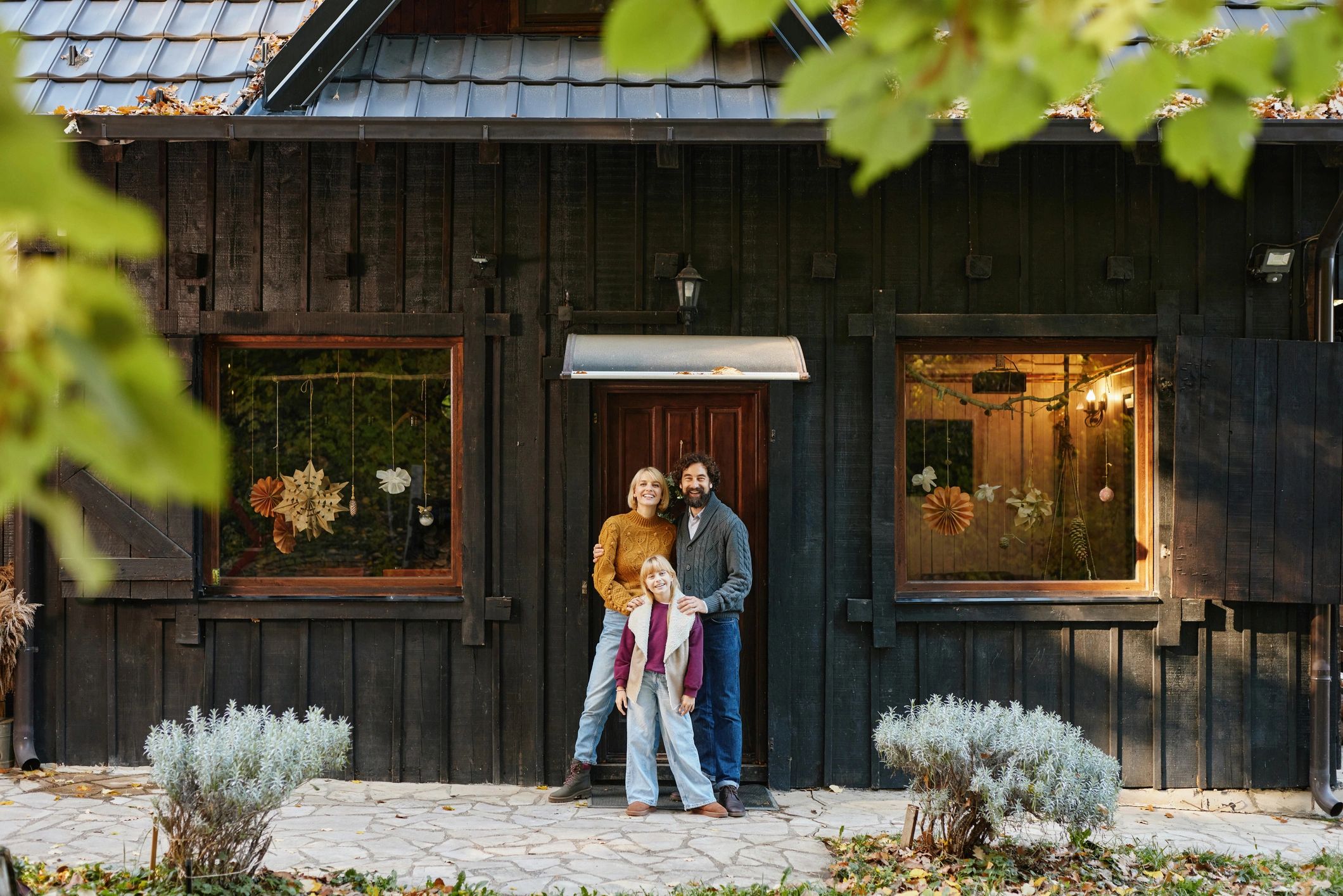 Family smiling outside a rustic home