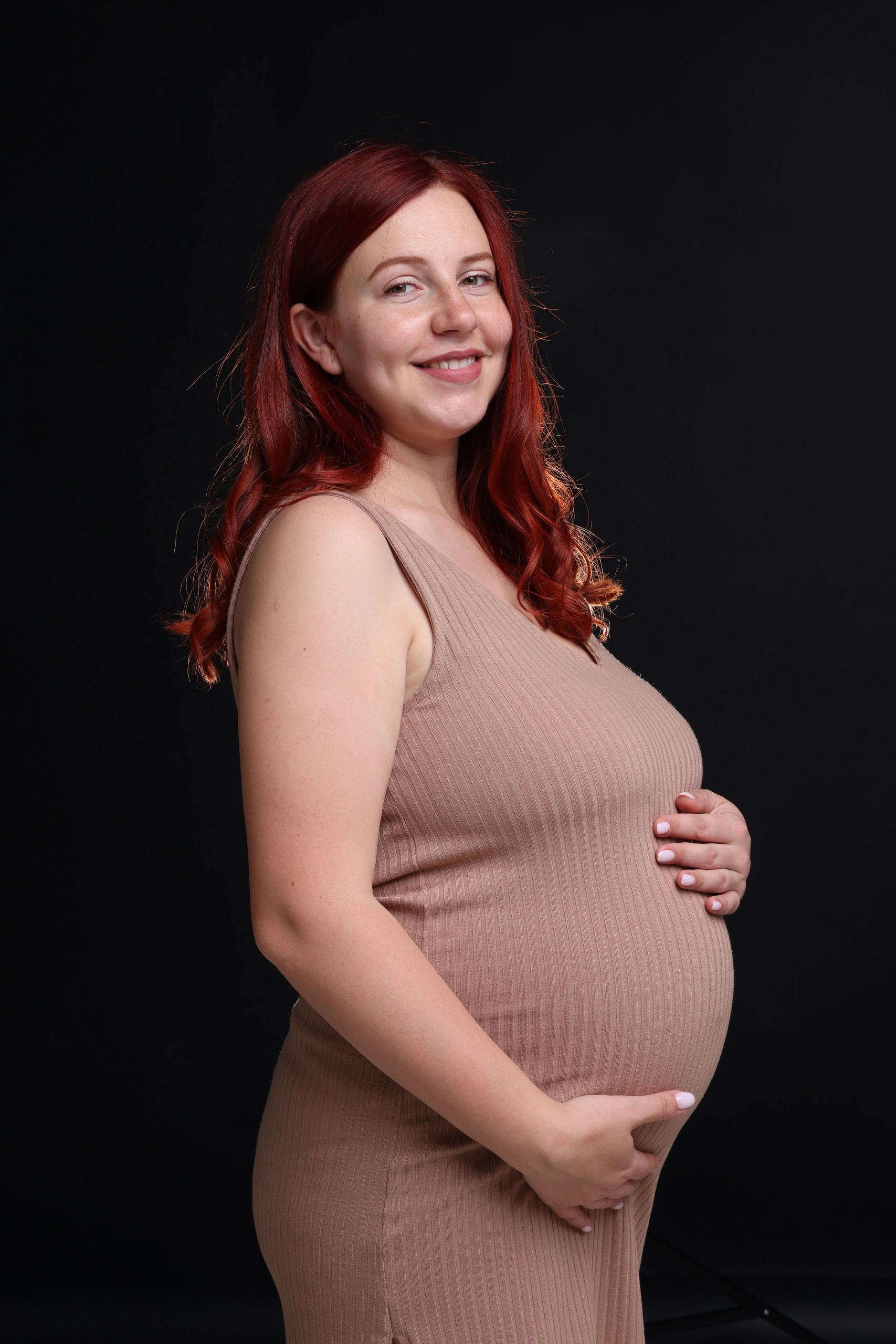 Fine art maternity portrait on a dark background