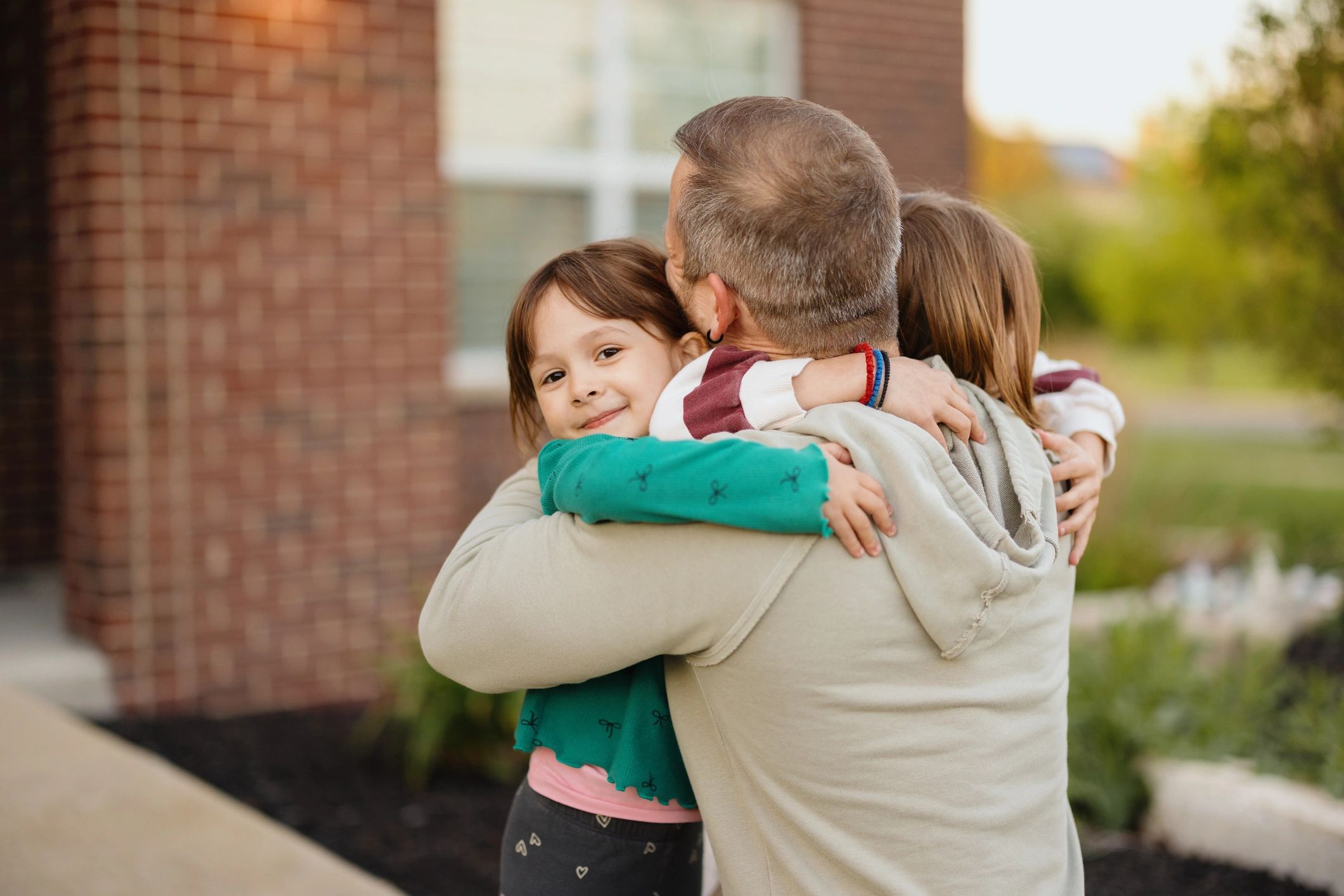Father embracing daughters outdoors